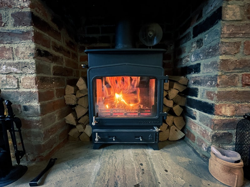 Wood burning stove with fire lit in brick hearth