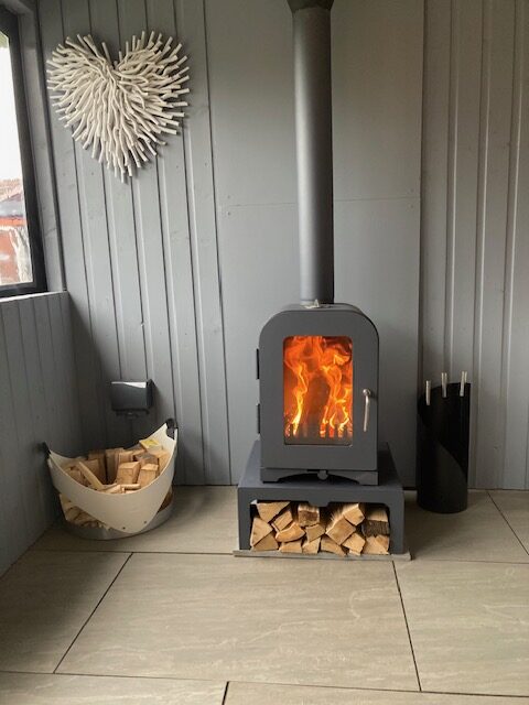 Compact wood burning stove with log store